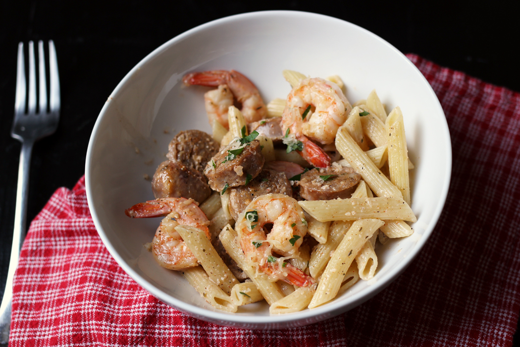 fork and individual bowl of creamy shrimp pasta on red napkin