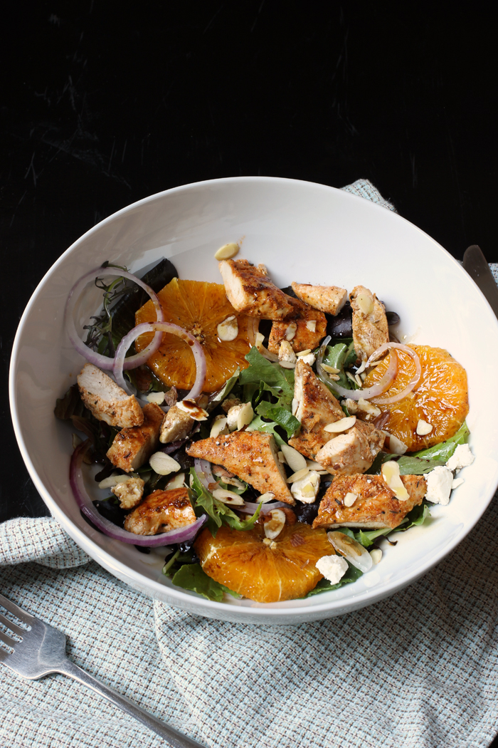 bowl of salad with chopped chicken, orange slices, and feta cheese