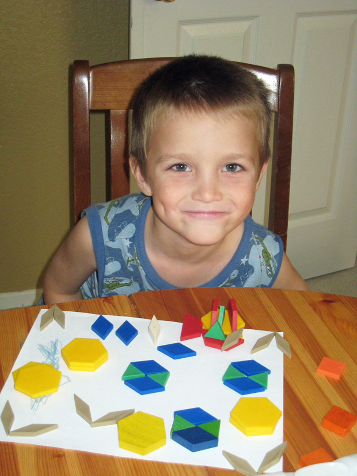 boy with pattern blocks on kitchen table.