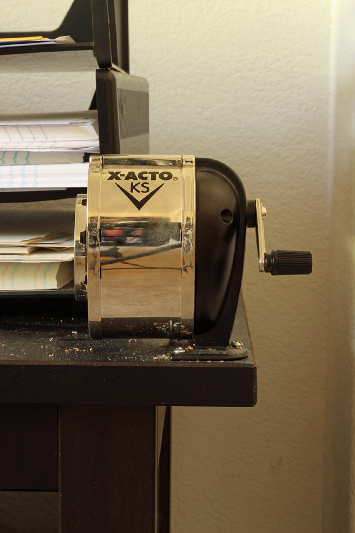 silver pencil sharpener attached to black table.