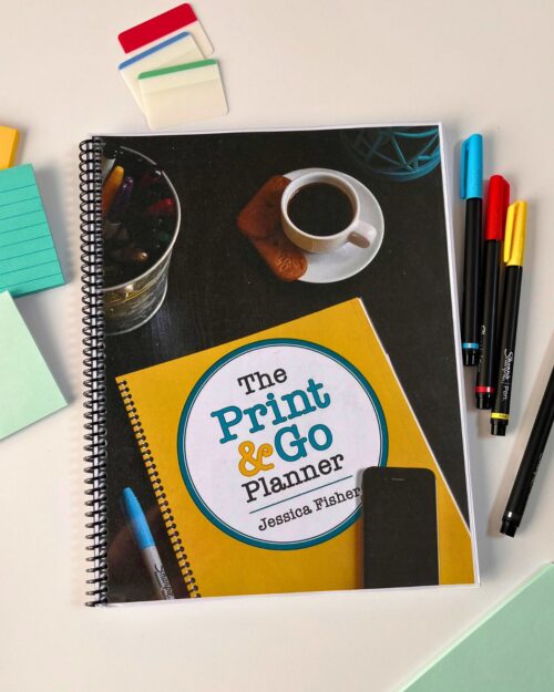 printable planner on white surface with pens and post-its.