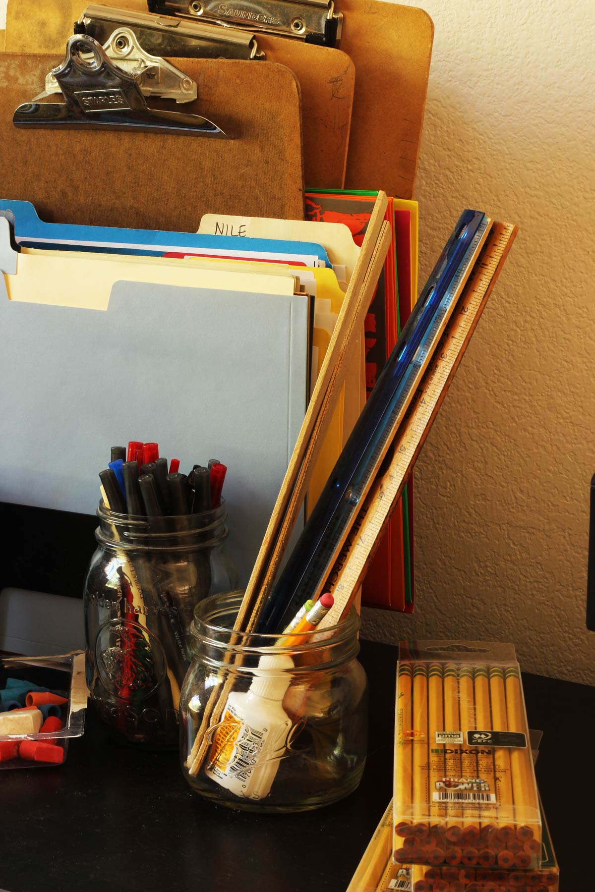 clipboards and other school supplies on a black table.