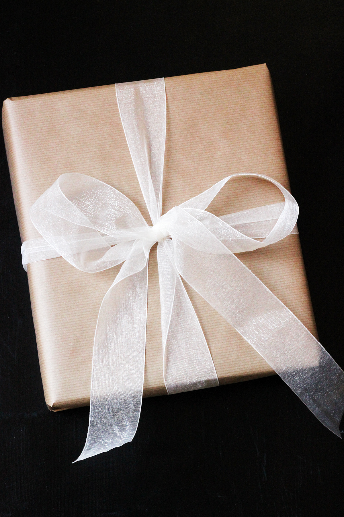 gift wrapped in brown paper and white filmy bow