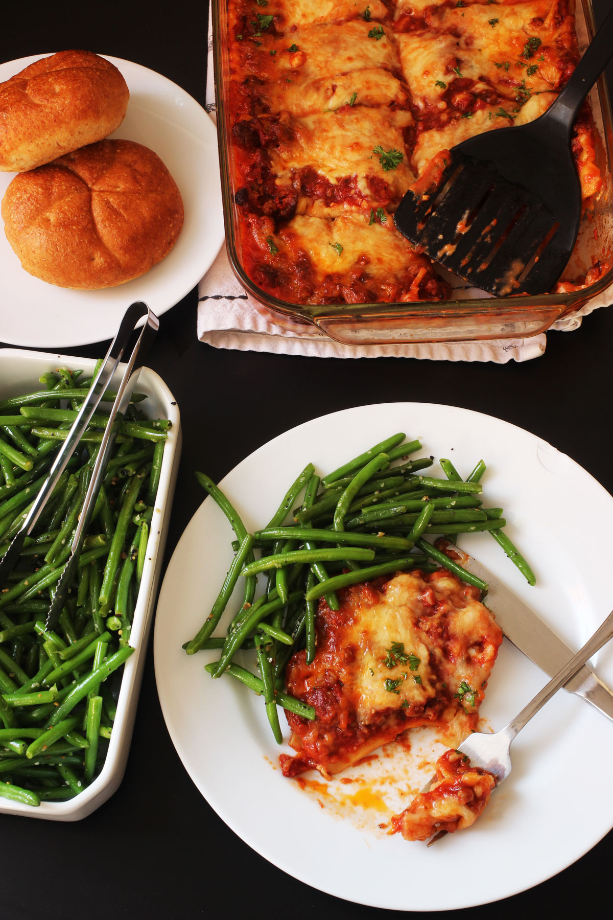 dinner table set with lasagna and green beans