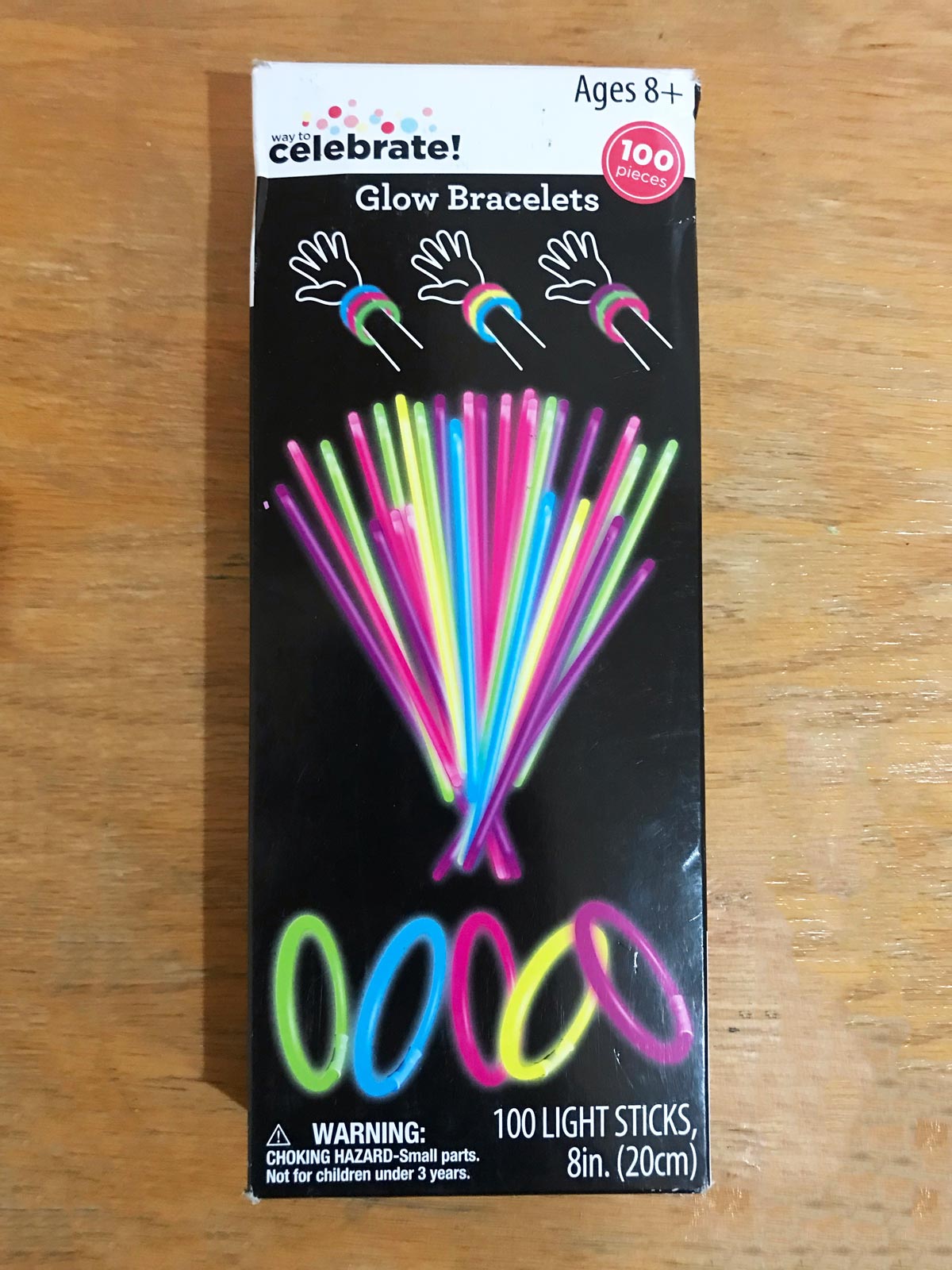 box of glow stick bracelets on wood desk.