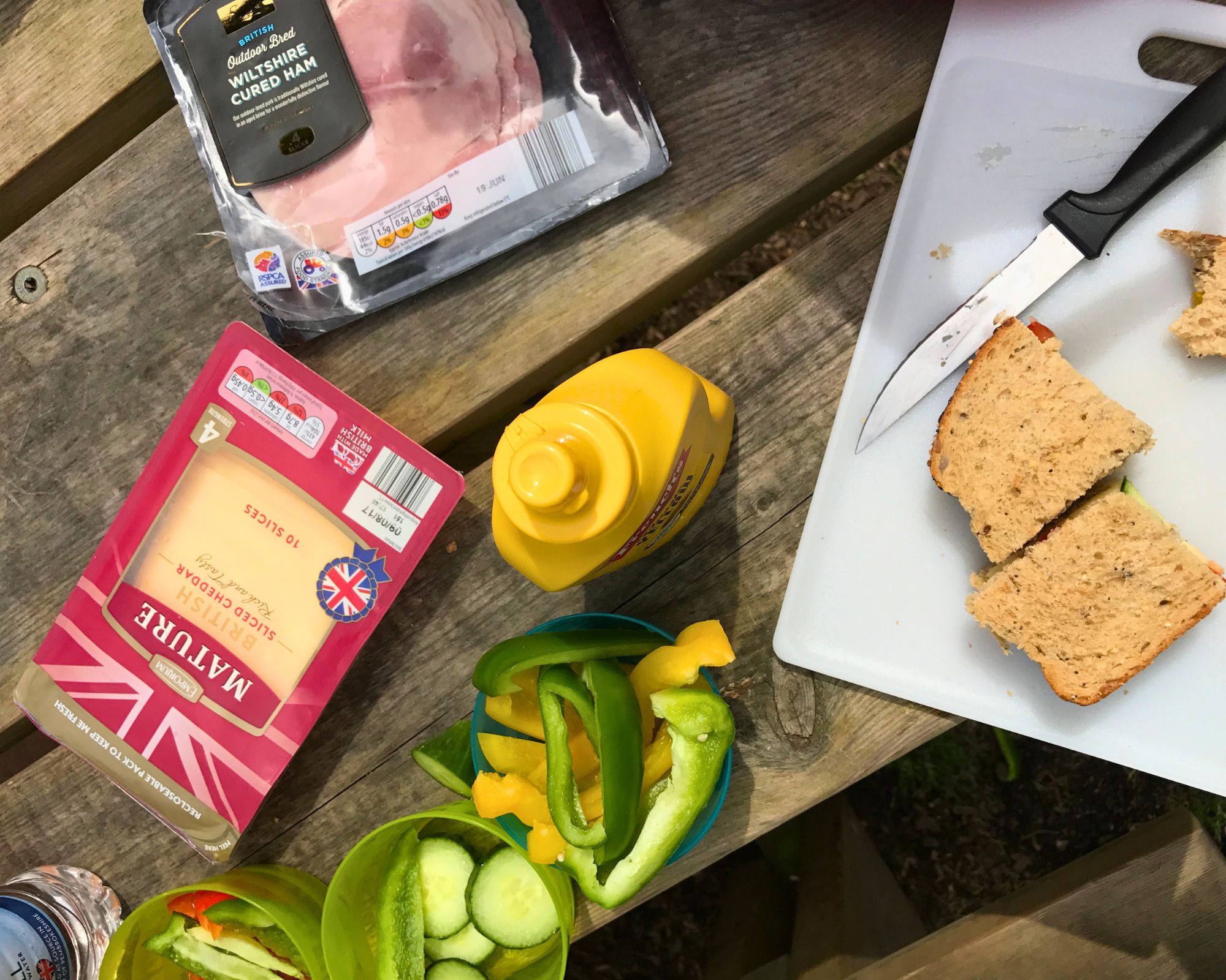 picnic table at park laden with grocery store picnic items.