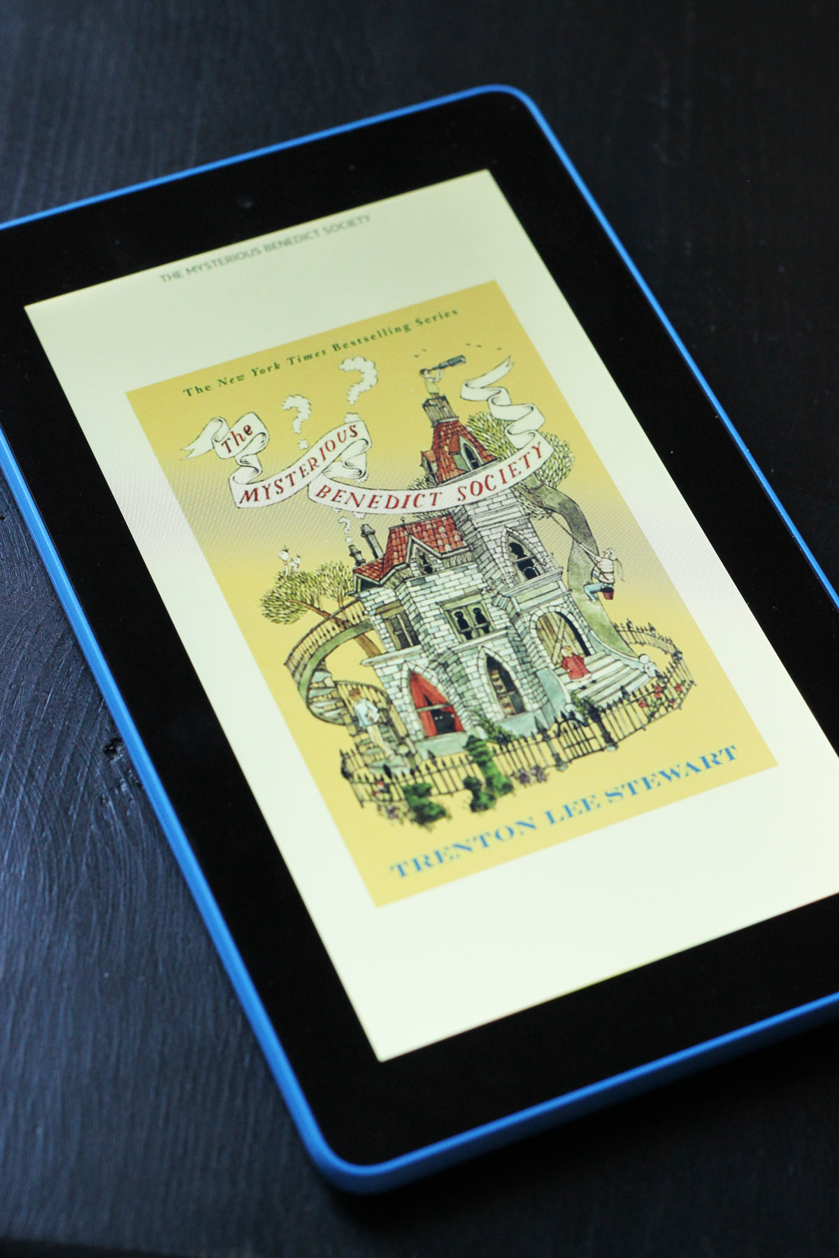 cover of the Mysterious Benedict Society on Kindle on black table.