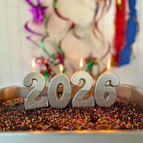 square crop of 2026 cake with lit candles.