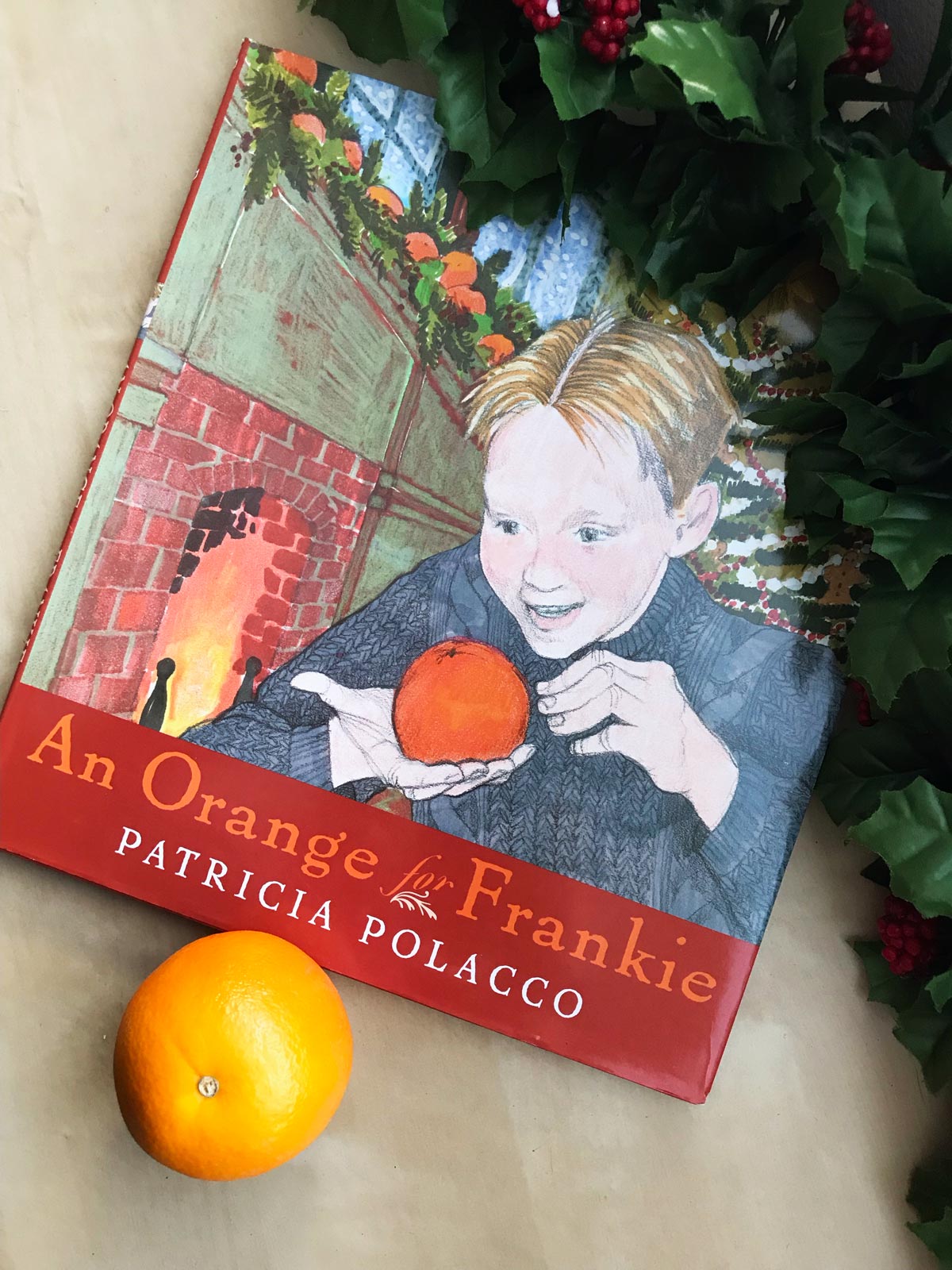 hard copy of An Orange for Frankie on table with an orange.