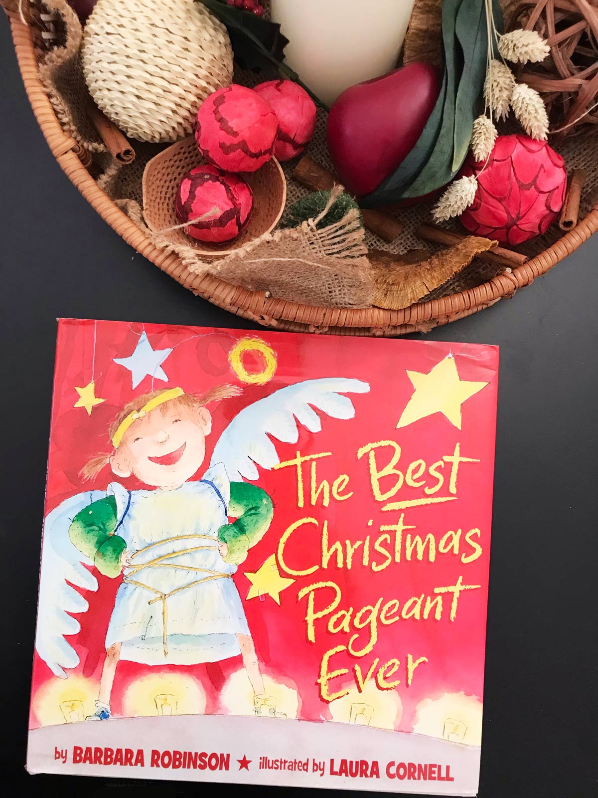 hard copy of best christmas pageant ever near basket of christmas decor.