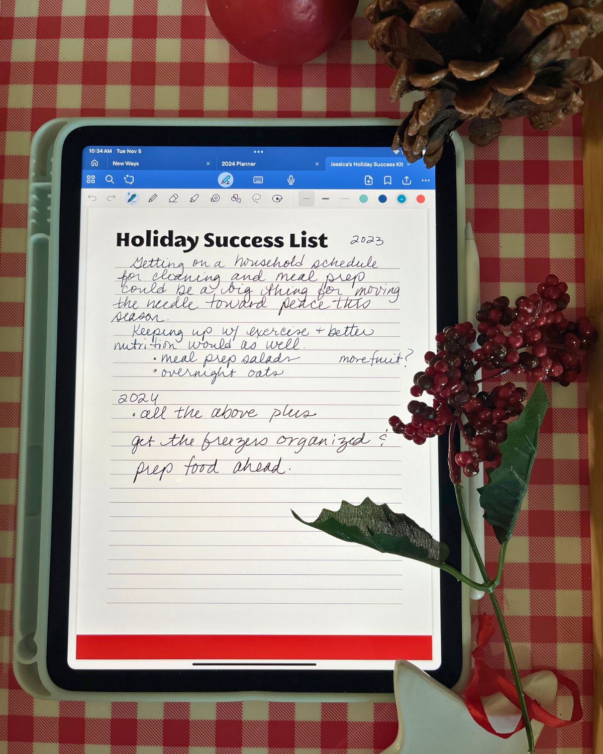 holiday success list on iPad on checked tray with Christmas decor.