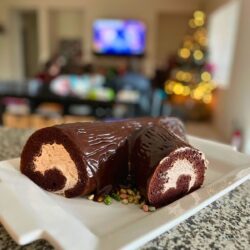 Chocolate buche de noel in front of christmas family room.