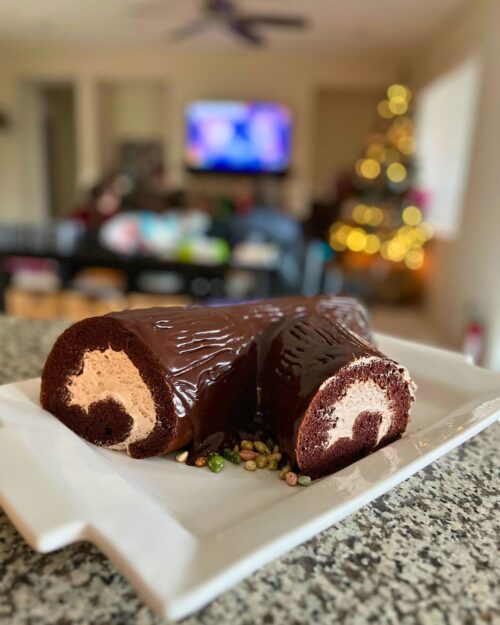 Chocolate buche de noel in front of christmas family room.