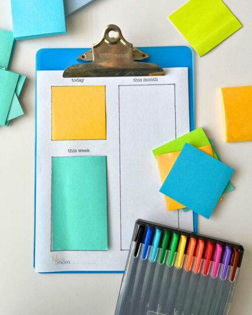 array of post-it notes with clipboard and to do list and pens.