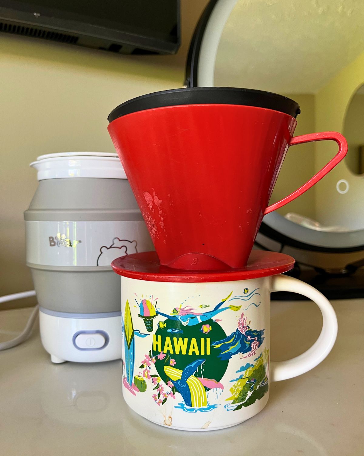 pour over filter on hawaii mug next to bear collapsible kettle.