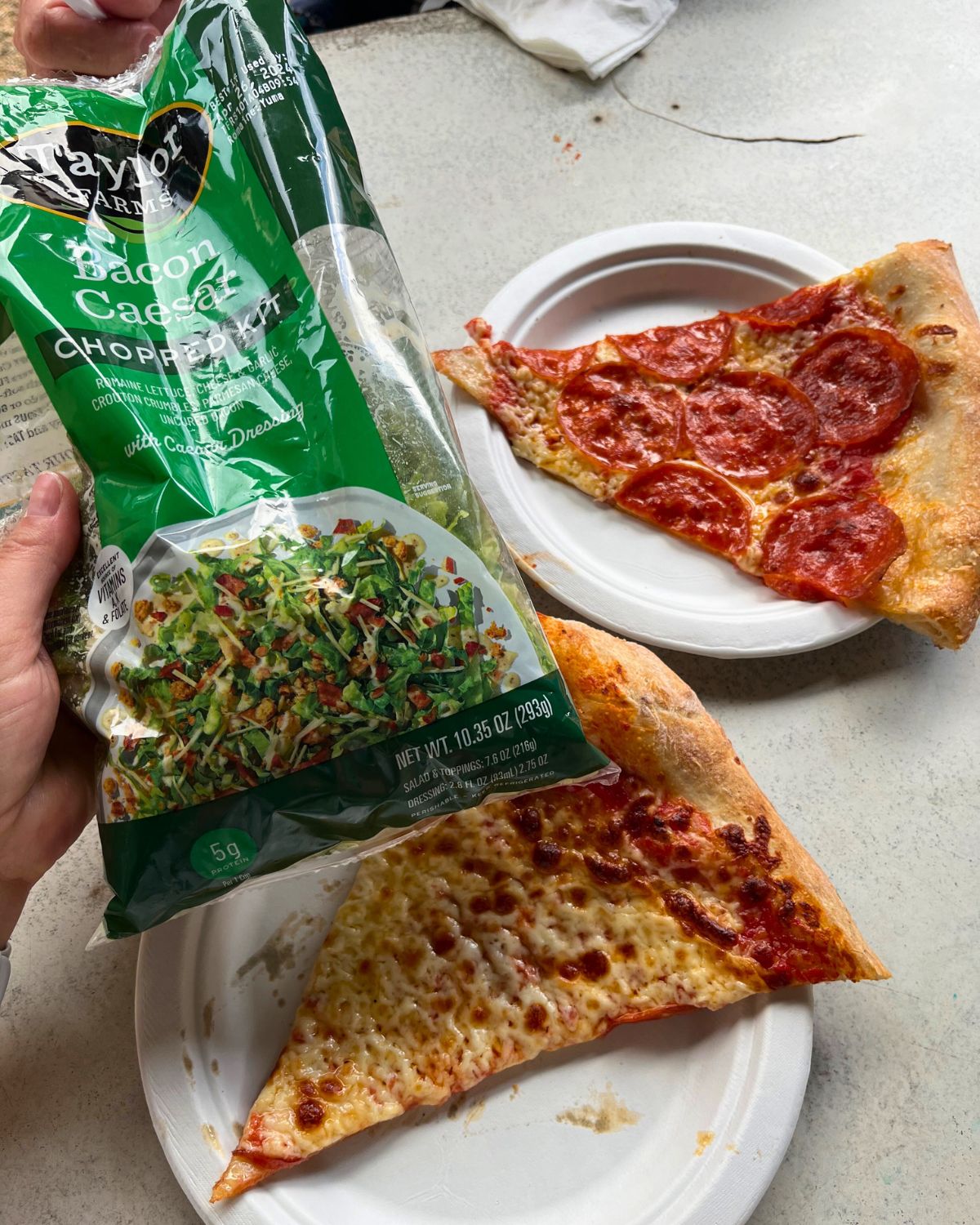 bagged salad with two slices of pizza.
