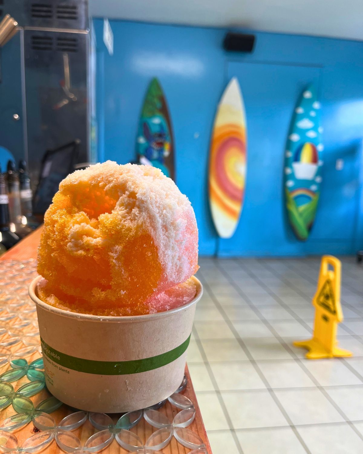 shave ice on the counter with surf boards in the background.