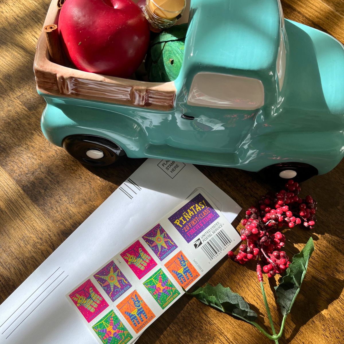 holiday decor next to envelope and stamps to pay a bill.