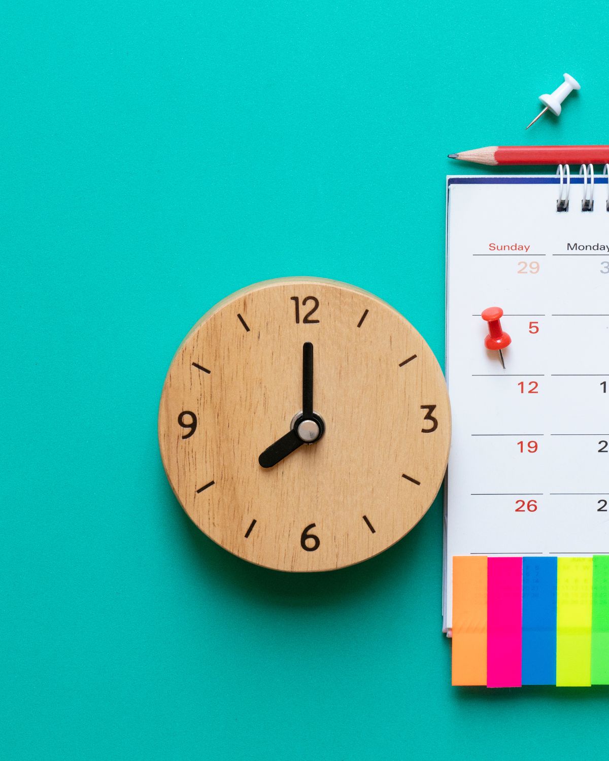 clock of teal background with calendar with post-its.