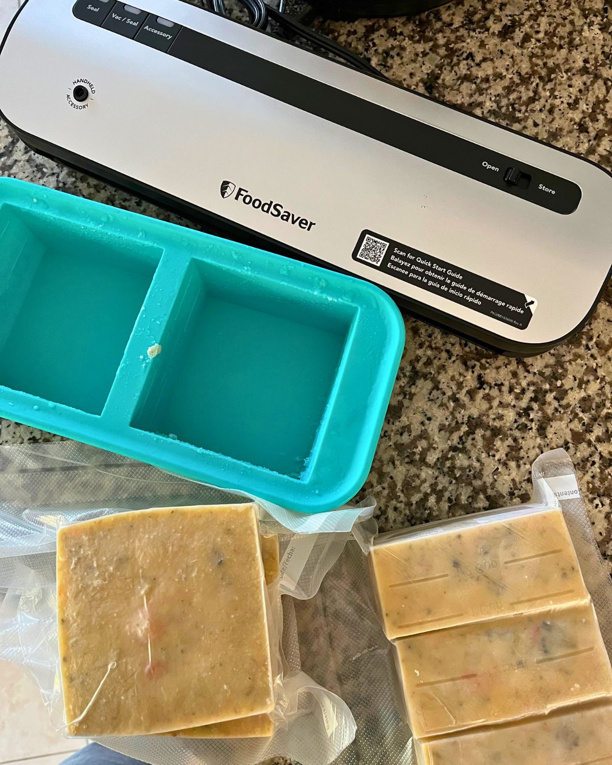 food saver on counter with empty soupercube and frozen soup in shrink wrap.