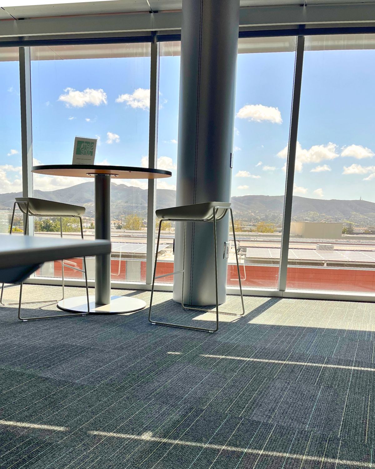view of the library with the big windows of the sky and mountains.