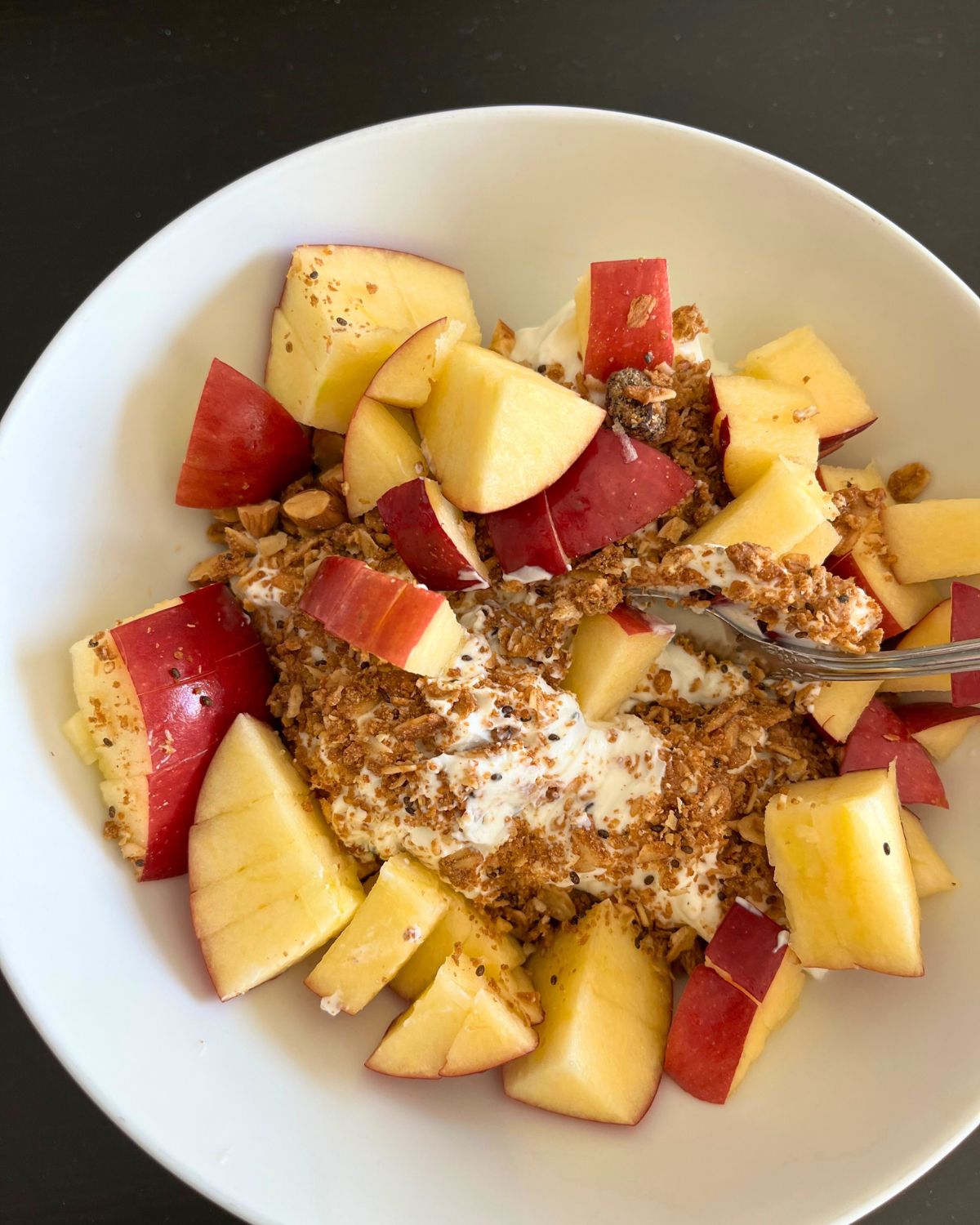 bowl of apples, yogurt, and granola.
