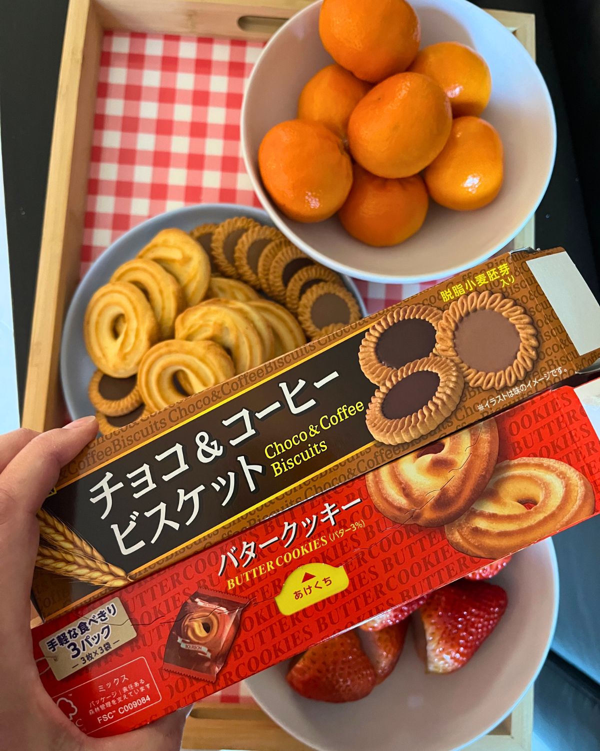 a tray with fruit and cookies as well as japanese cookie boxes.
