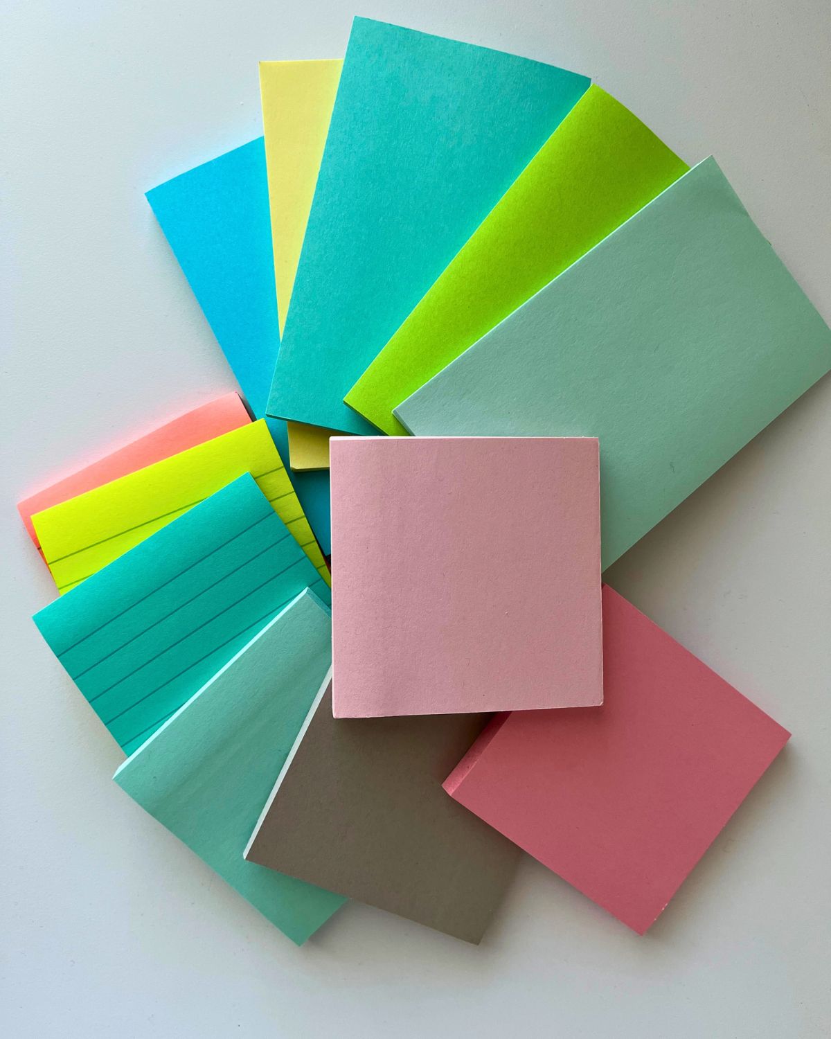 array of post it note pads on white table.