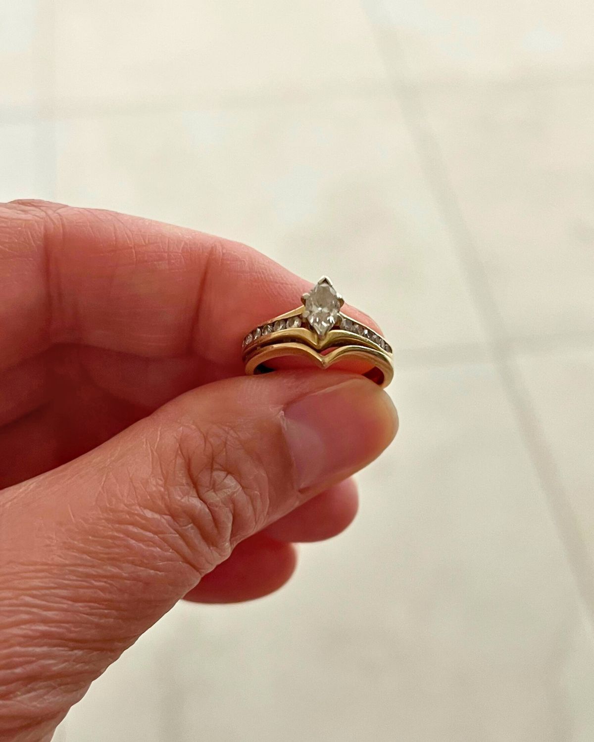 holding wedding ring between thumb and forefinger.