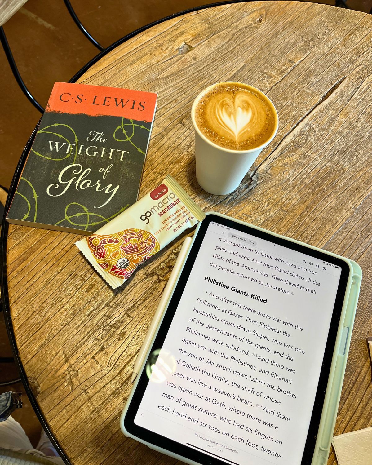 cs lewis book, protein bar, flat white, and iPad on cafe table.