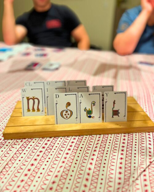 quibbler cards in wooden card holder on red striped tablecloth.