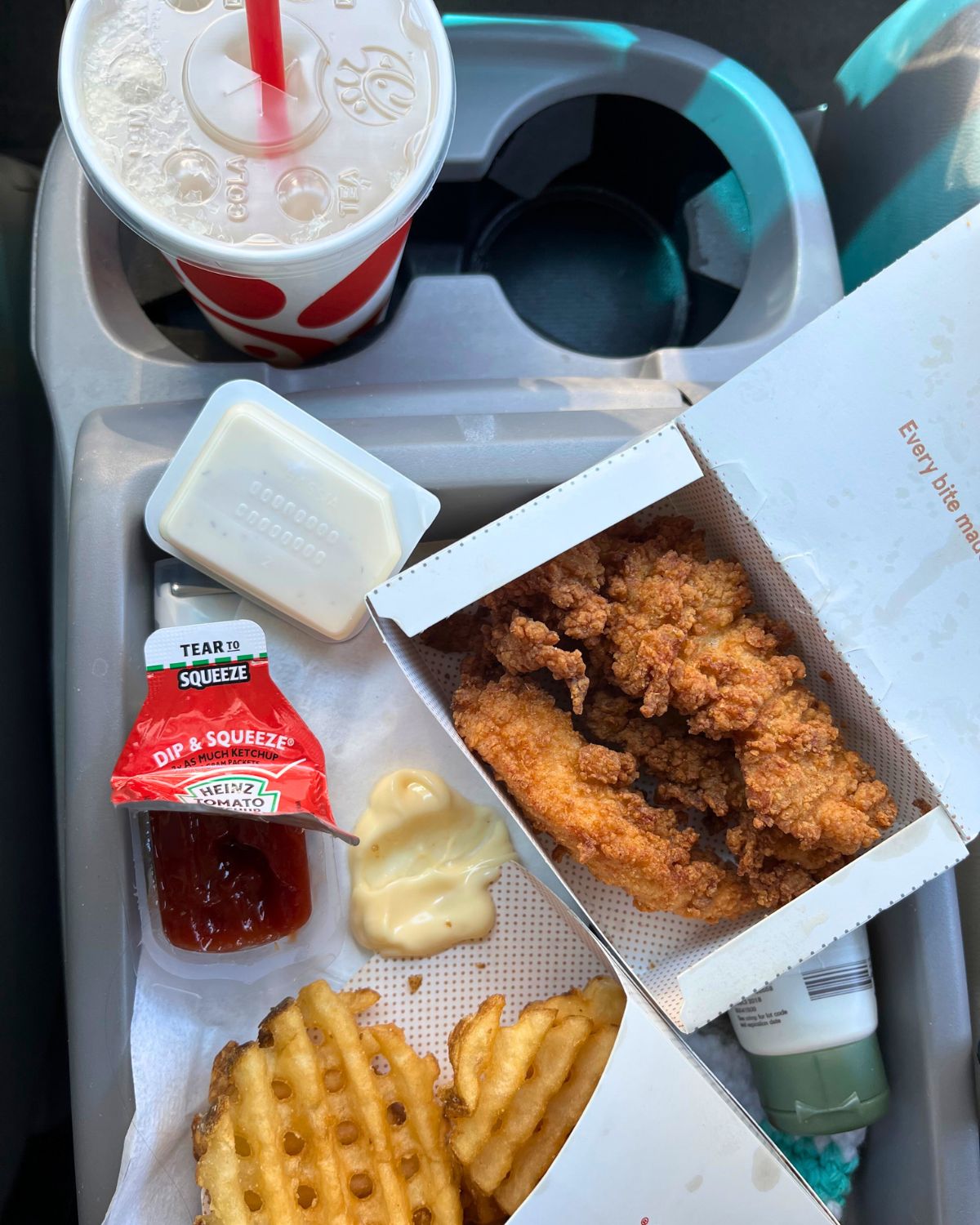 chick-fil-a lunch in the car spread on the console.