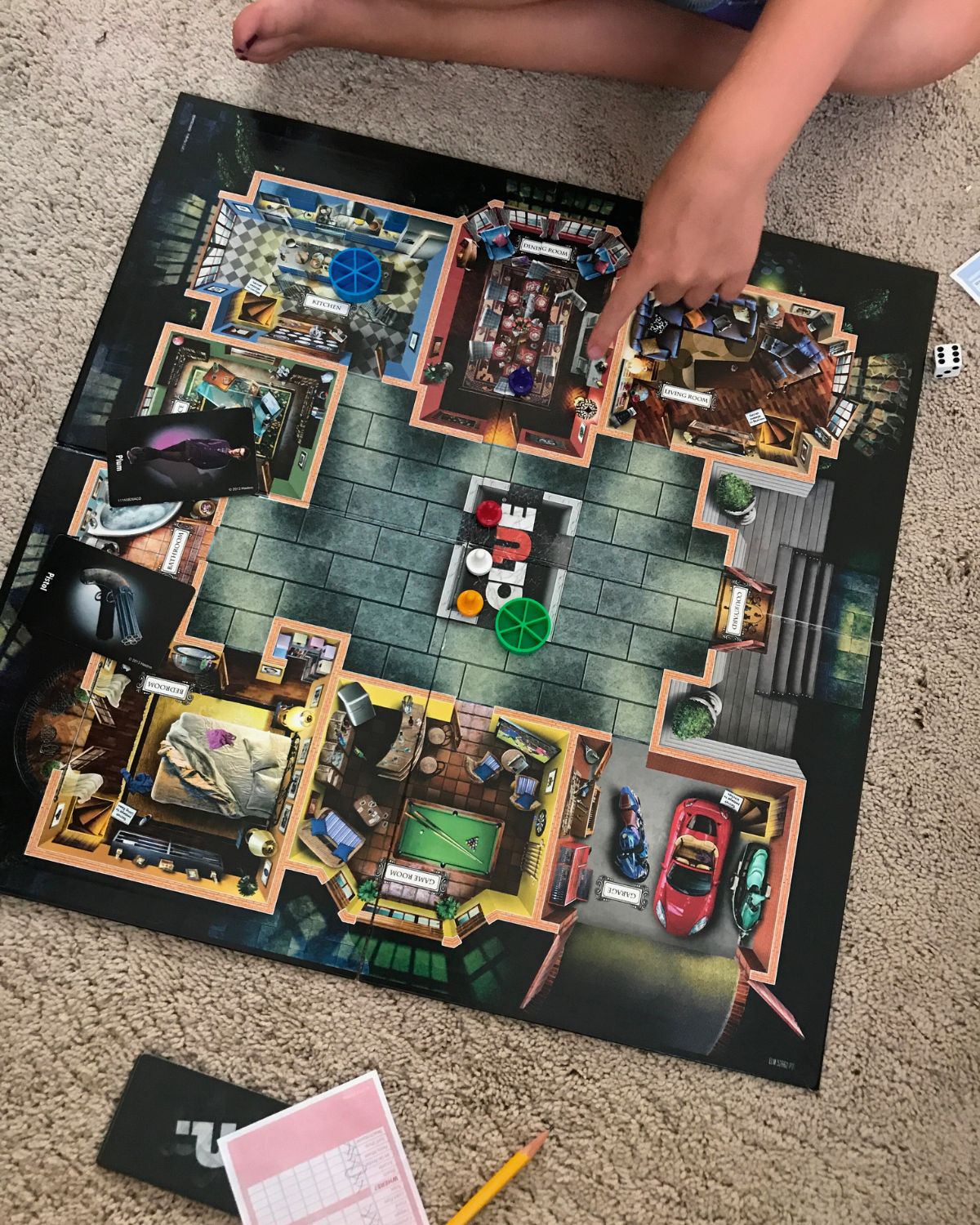 kids playing clue board game on carpet.