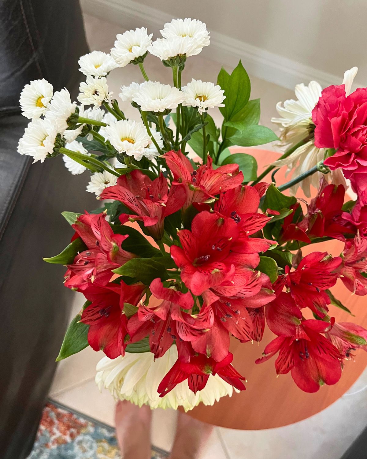 bouquet of red and white flowers on small table in library.