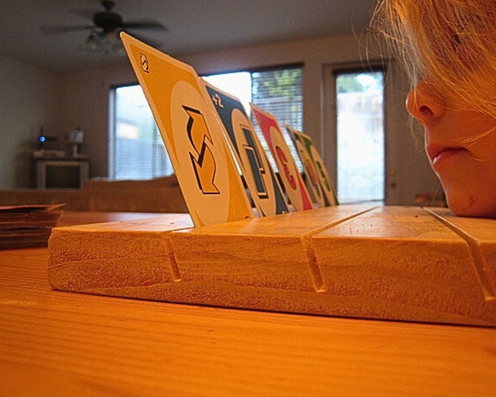 girl looking at her uno cards displayed in playing card holder.