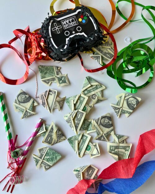 origami fish made of dollar bills with birthday decor.