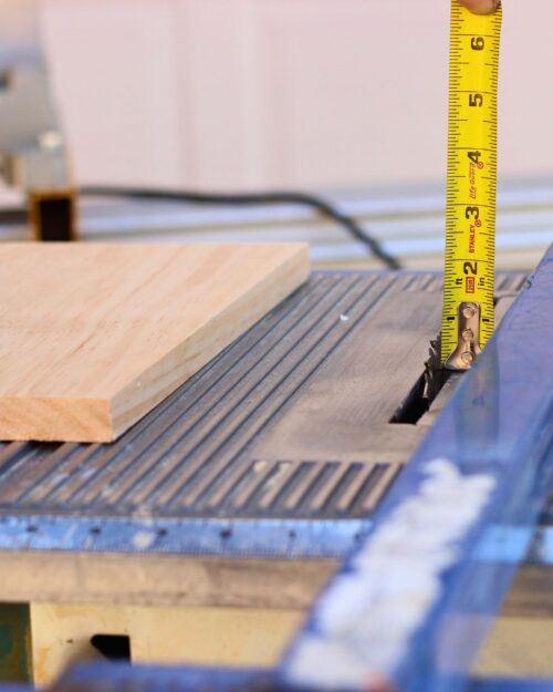 using tape measure and saw to cut channels in planks.