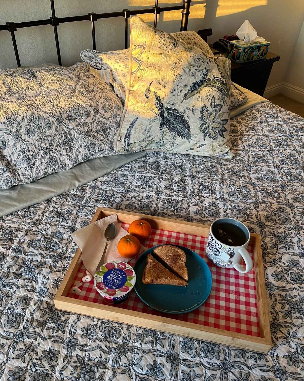 breakfast tray on bed with sunlight shining in.