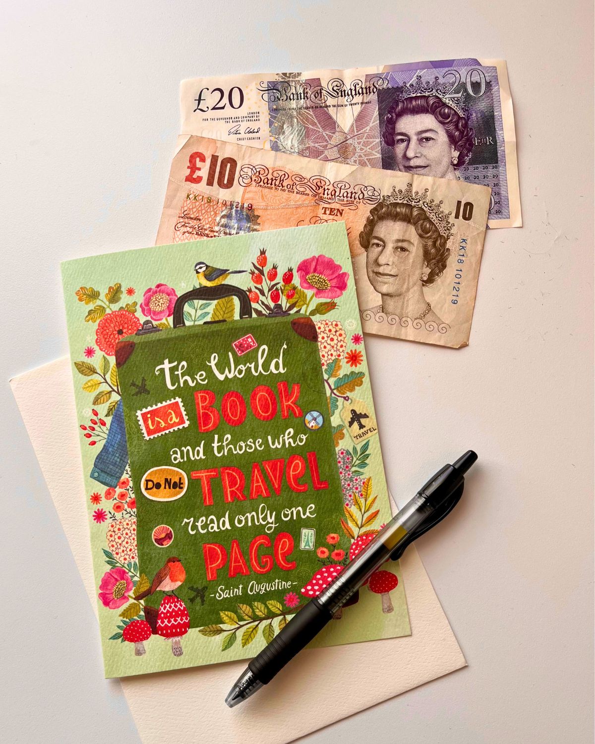 greeting card and british pounds on table with pen.