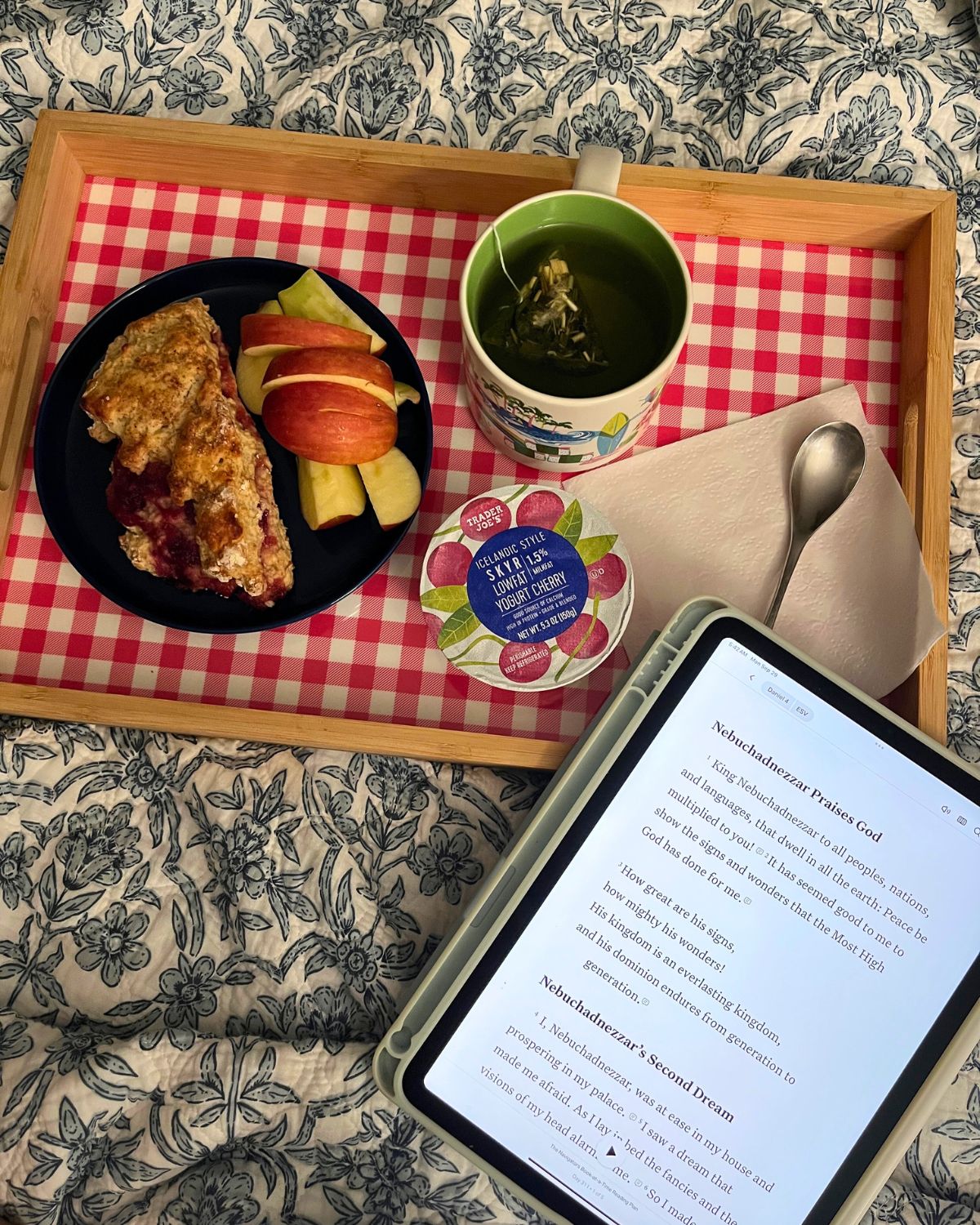 breakfast tray on bed with iPad open to bible page.