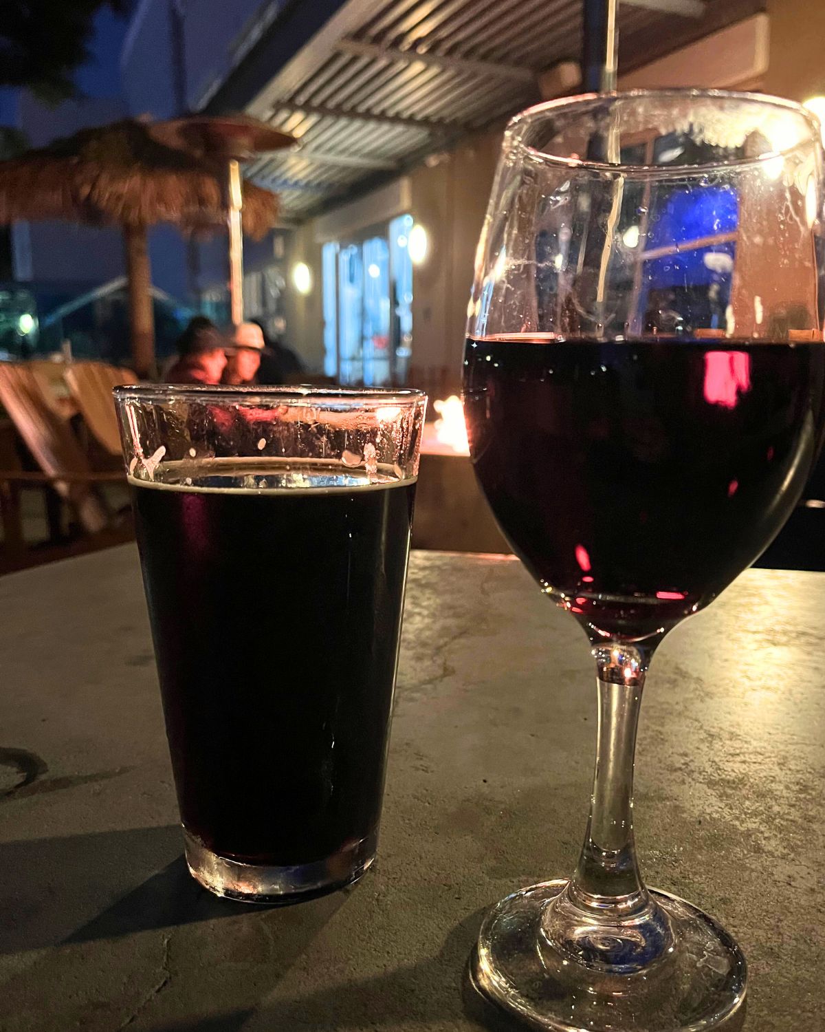 beer glass and wine glass backlit by fire at pizza port.