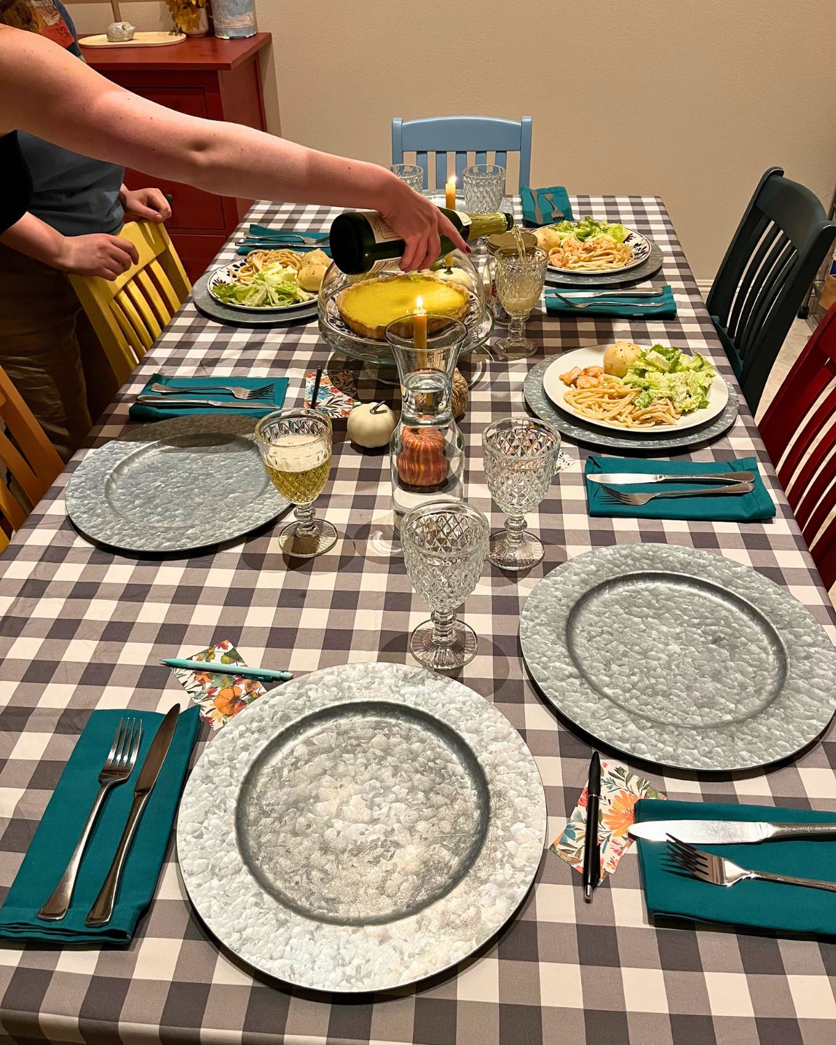 the sunday table set for dinner, with hands pouring cider into goblets.