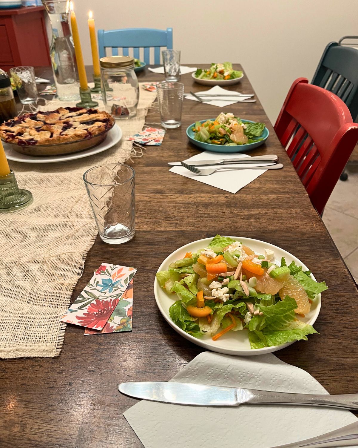 sunday dinner with salads laid at places and pie in center of table.