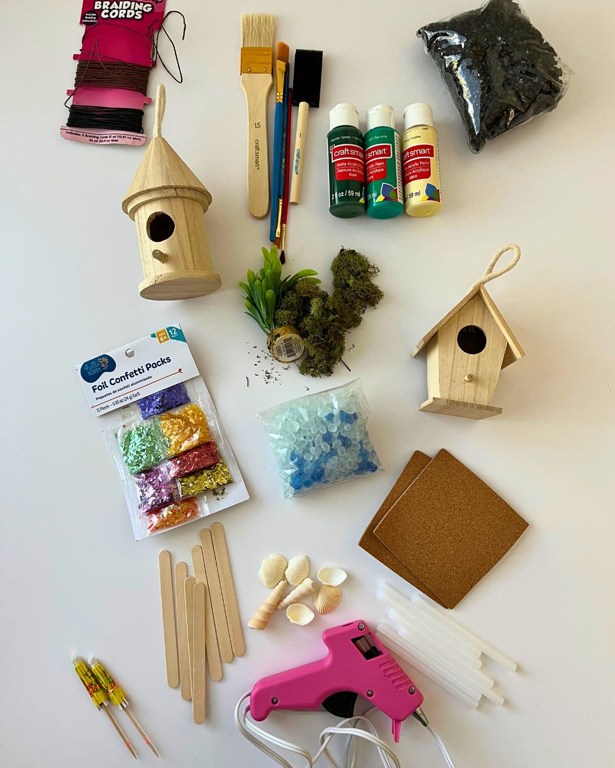 supplies for painting birdhouses arrayed on a white countertop.