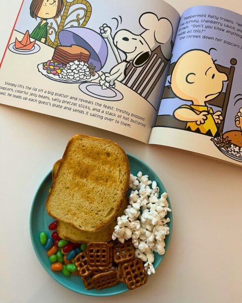 charlie brown thanksgiving dinner of popcorn, toast, pretzels, and jelly beans, with the book open to the dinner page.