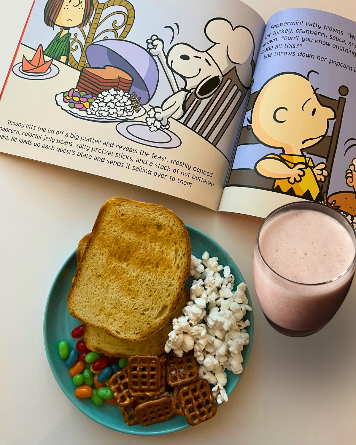 open story book next to plate of snacks and cup of smoothie.