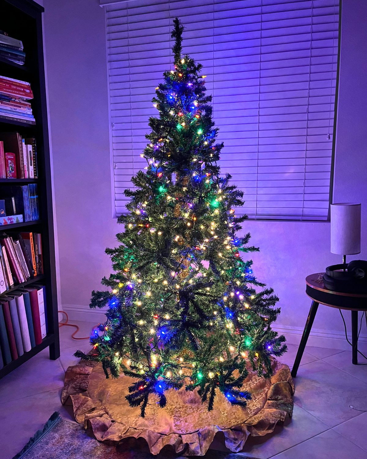 lit christmas tree reflecting purple glow on the room.