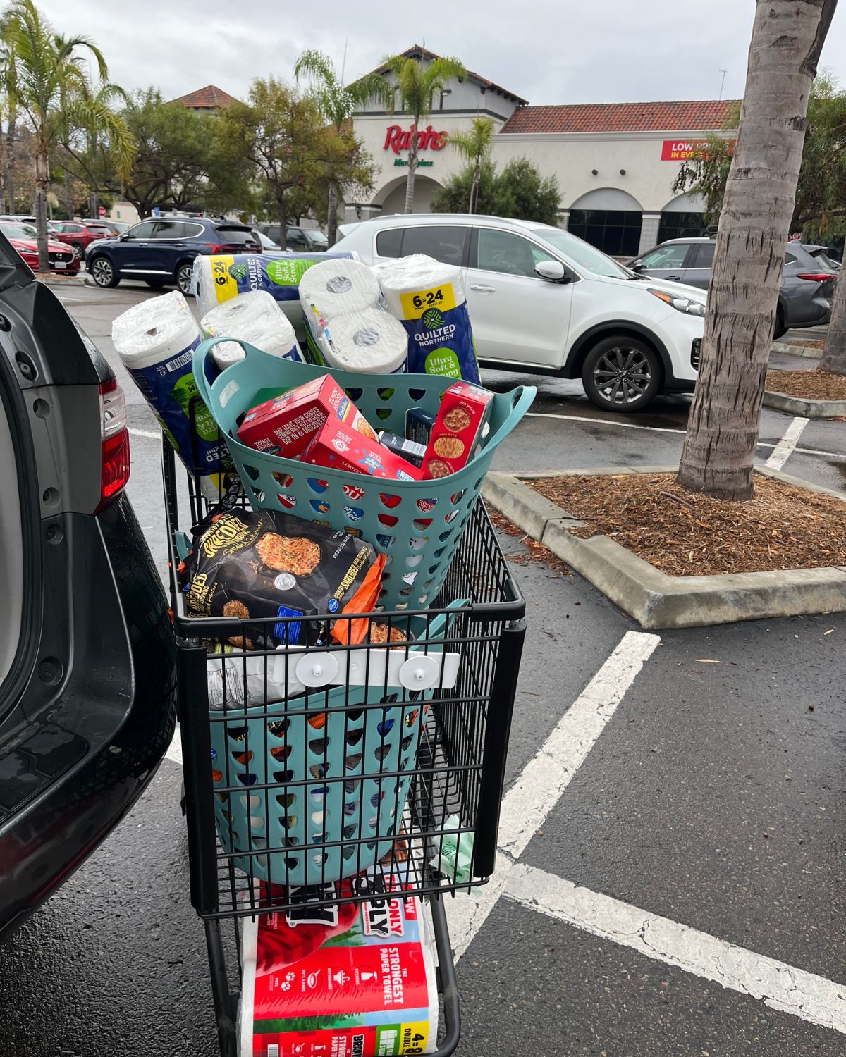 ralphs shopping cart overflowing in parking lot.