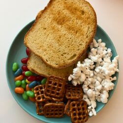 a snoopy thanksgiving dinner of toast, popcorn, pretzels, and jelly beans.