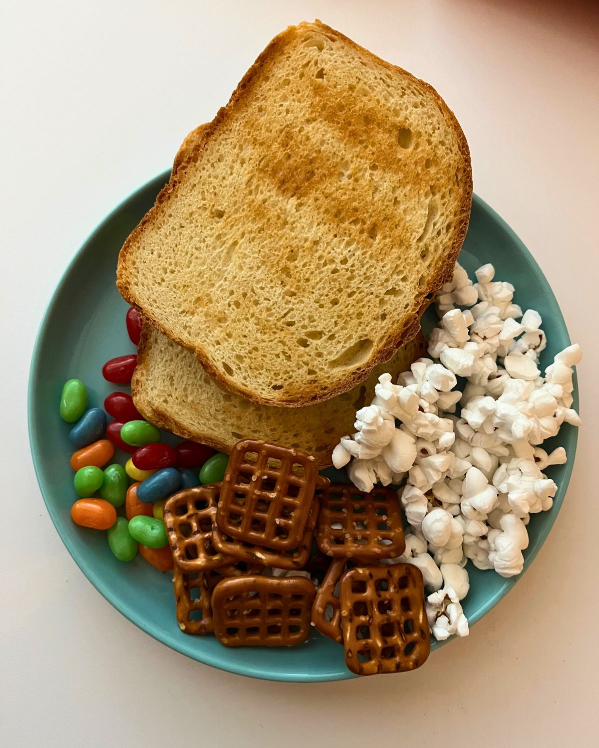a snoopy thanksgiving dinner of toast, popcorn, pretzels, and jelly beans.